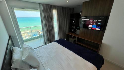 a bedroom with a bed and a view of the ocean at Studios Premium RN in Maceió