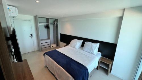 a bedroom with a large bed with a blue blanket at Studios Premium RN in Maceió