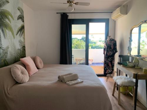 a bedroom with a bed with two towels on it at Sotogrande Duplex near Polo, 2 terraces, 2 pools, full south, 7' drive to beaches and Port, 4 people in Sotogrande