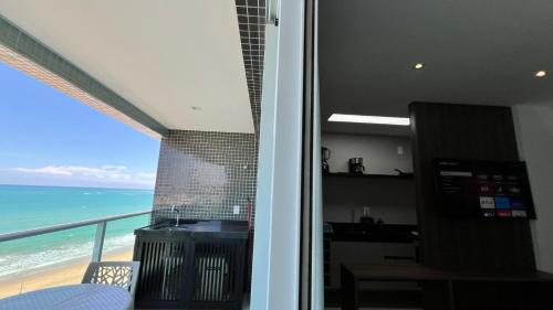 a kitchen with a view of the ocean from a balcony at Studios Premium RN in Maceió