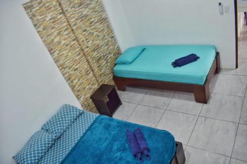 Habitación con 2 camas individuales y sábana azul. en Cahuita Apartment by Angie en Cahuita