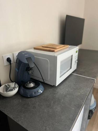 a microwave oven sitting on a counter with a blender at Le Nid in Le Havre