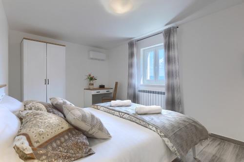 a bedroom with two beds with pillows and a window at Villa Pietro Montona in Motovun