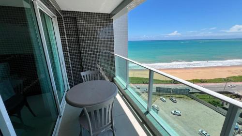 a balcony with a table and a view of the ocean at Studios Premium RN in Maceió
