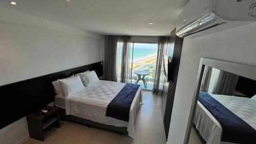 a hotel room with two beds and a balcony at Studios Premium RN in Maceió
