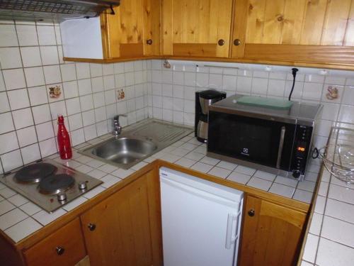 a small kitchen with a sink and a microwave at Studio 4 pers, Balcon Sud, Lave-vaisselle, Animaux acceptés - FR-1-404-62 in La Mongie