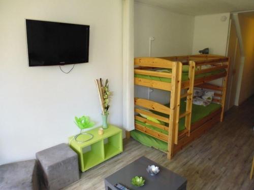 a living room with a bunk bed and a flat screen tv at Studio 4 pers, Balcon Sud, Lave-vaisselle, Animaux acceptés - FR-1-404-62 in La Mongie