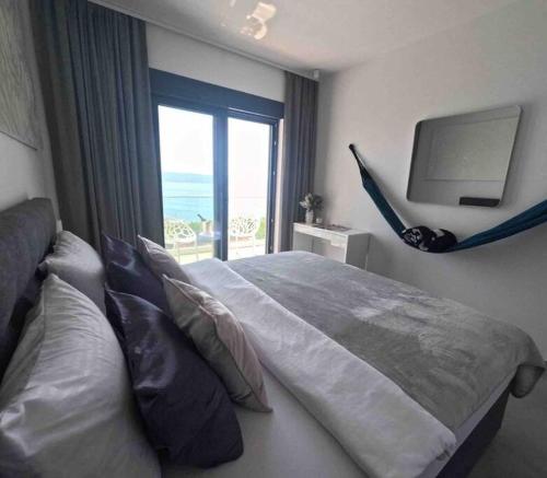 een slaapkamer met een bed, een tv en een raam bij New! Luxury Boutique Villa Fay, heated Pool, Jacuzzi, Seaview near Split and Omis in Dugi Rat