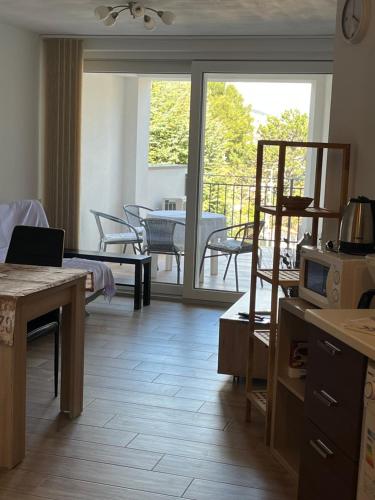 a living room with a kitchen and a balcony with a table at Apartments More in Baška