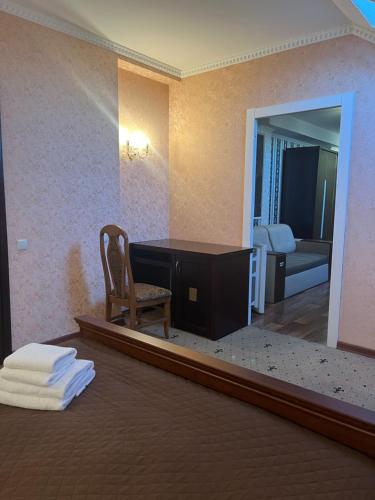 Habitación con escritorio, silla y espejo. en Hotel Lavilia en Kiev