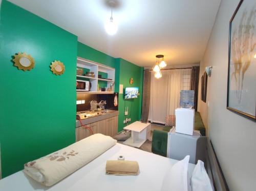 Cette chambre verte comprend un lit et un mur vert. dans l'établissement Tsavo Royal Suburbs, à Nairobi