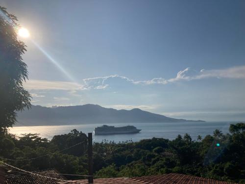 a view of the ocean with a ship in the water at Casas No Centro Histórico (vila) in Ilhabela