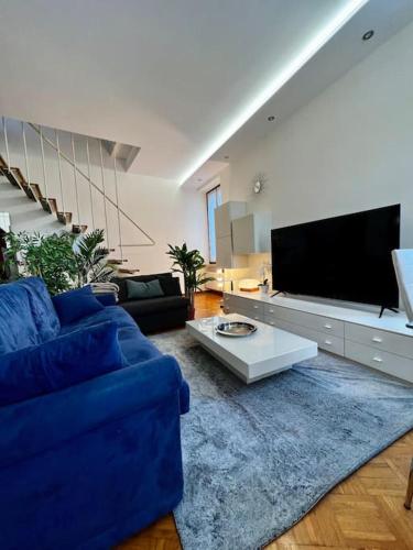 a living room with a blue couch and a tv at attico ARENA,200mq[NETFLIX-WIFI-AIR CONDITIONING] in Verona