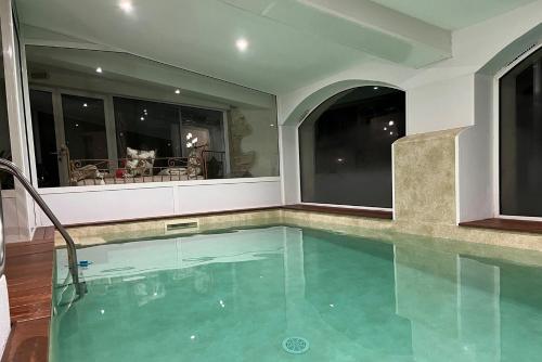 a swimming pool in a house with two windows at Le Mas Du Pont Roman in Mane