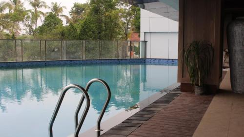 a swimming pool with two metal chairs next to it at Kangen Amarta in Sleman