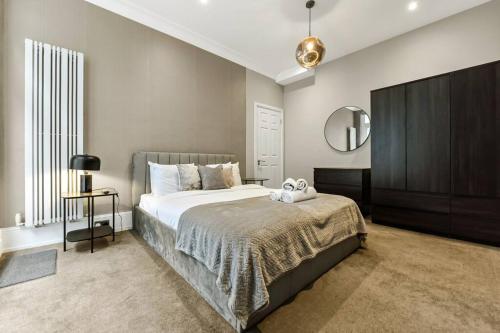a bedroom with a large bed and a mirror at Mayfair Apartment with Private Terrace! in London