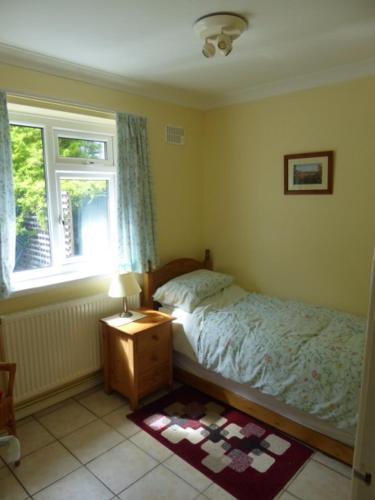 een slaapkamer met een bed en een raam bij Sea view bungalow in The Mumbles
