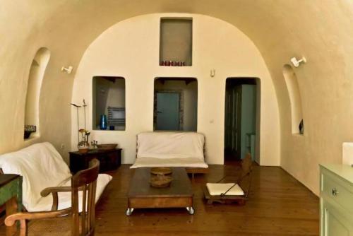a living room with two beds and a table at Hanging at the top of the world in Oia