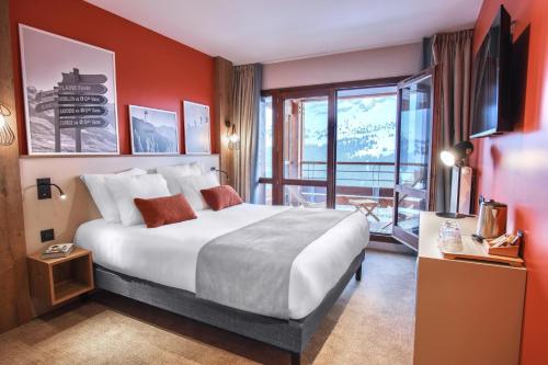フレーヌにあるBelambra Clubs Flaine Panoramaの大きなベッドとバルコニーが備わるホテルルームです。