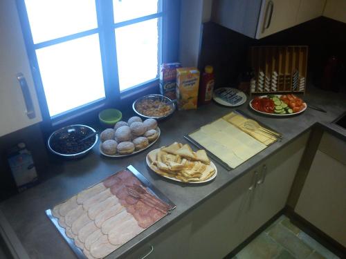 a kitchen counter with many plates of food on it at Chata - Srub Kašparáci in Janske Lazne