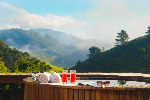 a table with glasses and plates on a table with a view of mountains at Maua Brasil Hotelaria in Visconde De Maua