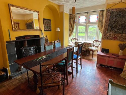 a dining room with a table and a mirror at Tintern Old Rectory in Tintern