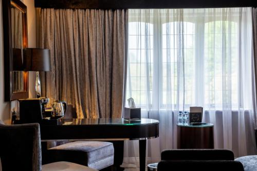 a hotel room with a desk and a window at Derwent Manor Boutique Hotel in Consett