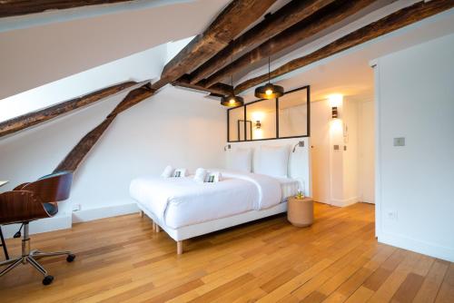 une chambre avec un lit blanc et un bureau dans l'établissement Rooftops of Paris l Opéra - Madeleine, à Paris