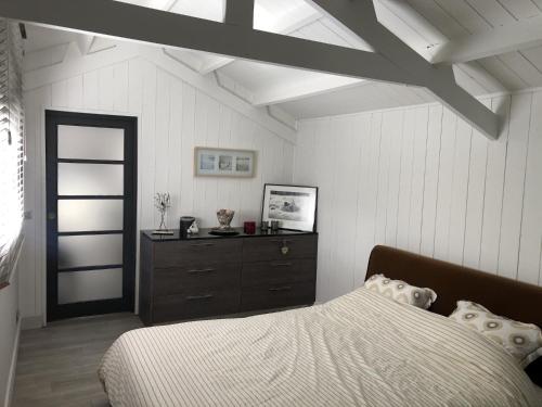 une chambre avec un lit et une commode dans l'établissement Les Platanes, à Duingt