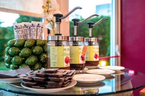 a glass table topped with bottles of pickles and snacks at Domino Suite Hotel & Residence in Lido di Jesolo