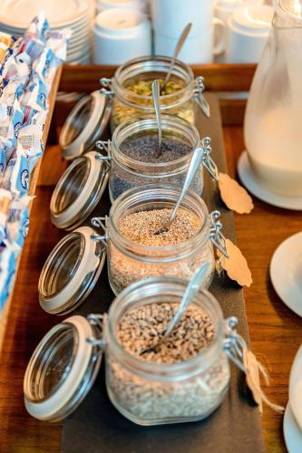 a group of four jars filled with food on a table at Domino Suite Hotel & Residence in Lido di Jesolo