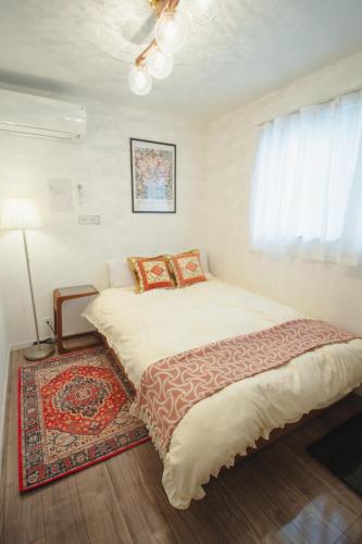 a bedroom with a large bed with a rug at QiQi Serenity Tokyo Exclusive New 3-Story Home, 14min to Skytree, Asakusa Area in Tokyo
