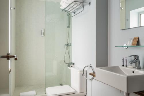 a bathroom with a shower and a toilet and a sink at Hotel Madanis Liceo in Hospitalet de Llobregat