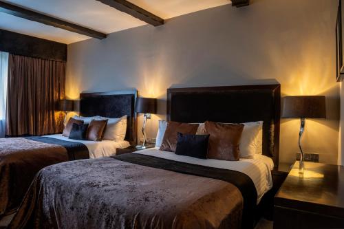 a hotel room with two beds and a window at Derwent Manor Boutique Hotel in Consett