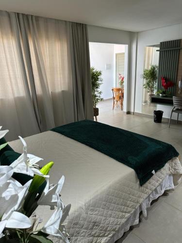 a bedroom with a large bed with a green blanket at HOTEL TERRA NATIVA in Alter do Chao