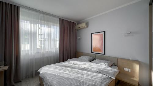 a bedroom with a bed and a window at Damaris Apartments 2 in Chişinău