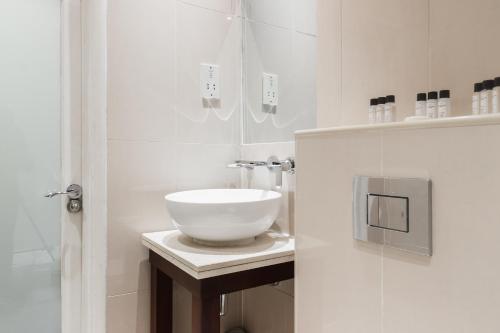 ein Badezimmer mit einem weißen Waschbecken auf der Theke in der Unterkunft Park Grand Hyde Park in London