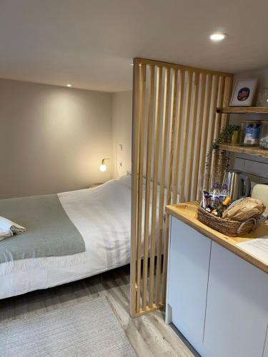 El Nido - Self Catering cabin in Southbourne, 5 mins from beach في Iford: غرفة نوم بسرير وتقسيم خشبي