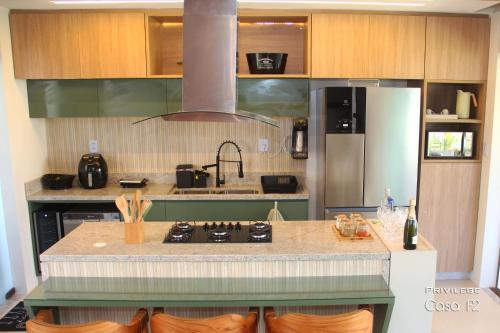 a kitchen with a stove and a refrigerator at Exclusivo 2 suites a Beira Mar Imbassaí Privilege in Imbassai