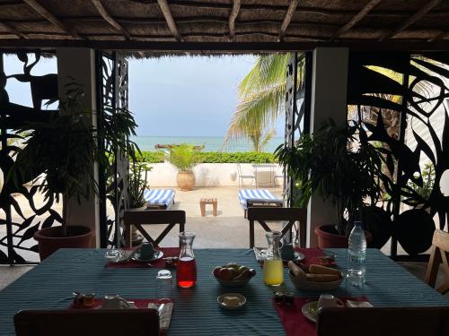 a table with a blue table cloth and a view of the ocean at Bine Bassile in Guéréo