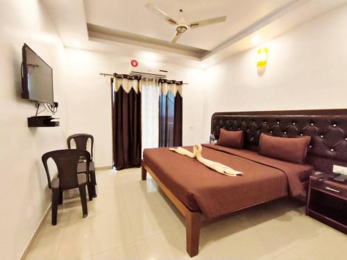 a bedroom with a bed and a flat screen tv at HOTEL NATURE SHIELD in Lonavala