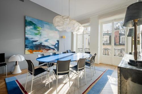 une salle à manger avec une table et des chaises bleues dans l'établissement Veeve - Orsay Artistry, à Paris
