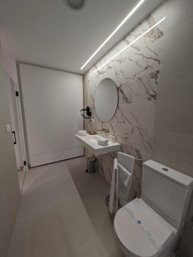 a bathroom with a toilet and a sink and a mirror at Gran Hotel Toledo in Onda