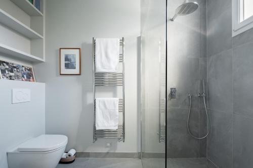 une salle de bain blanche avec douche et toilettes dans l'établissement Veeve - Orsay Artistry, à Paris