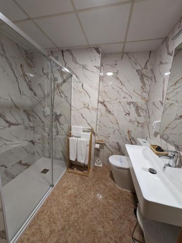 a bathroom with a shower and a sink and a toilet at Gran Hotel Toledo in Onda