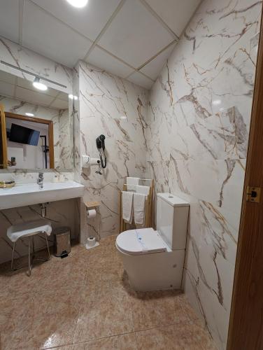 a bathroom with a toilet and a sink at Gran Hotel Toledo in Onda