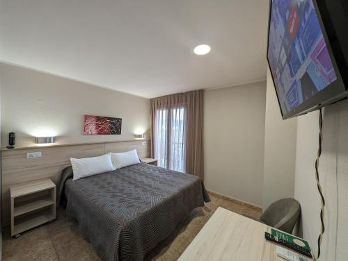 a hotel room with a bed and a flat screen tv at Gran Hotel Toledo in Onda