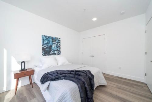 a white bedroom with a bed and a table at Cozy apt with great city view in Union City