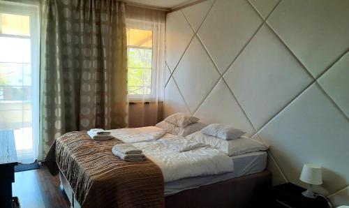 a bedroom with a bed with towels on it at Caballus Lovasmajor in Nyíregyháza
