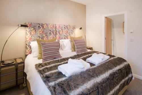 um quarto com uma cama grande e almofadas em Stables em Melrose